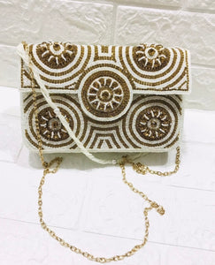 White and gold sling clutch bag